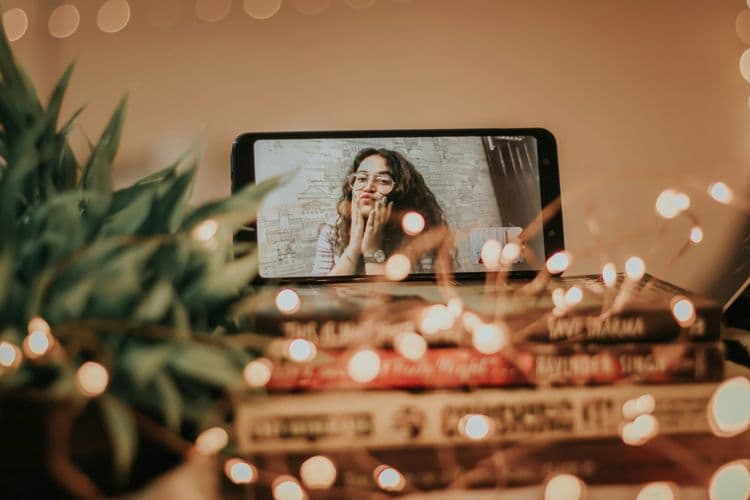 phone on table next to plant on facetime girl making kiss face